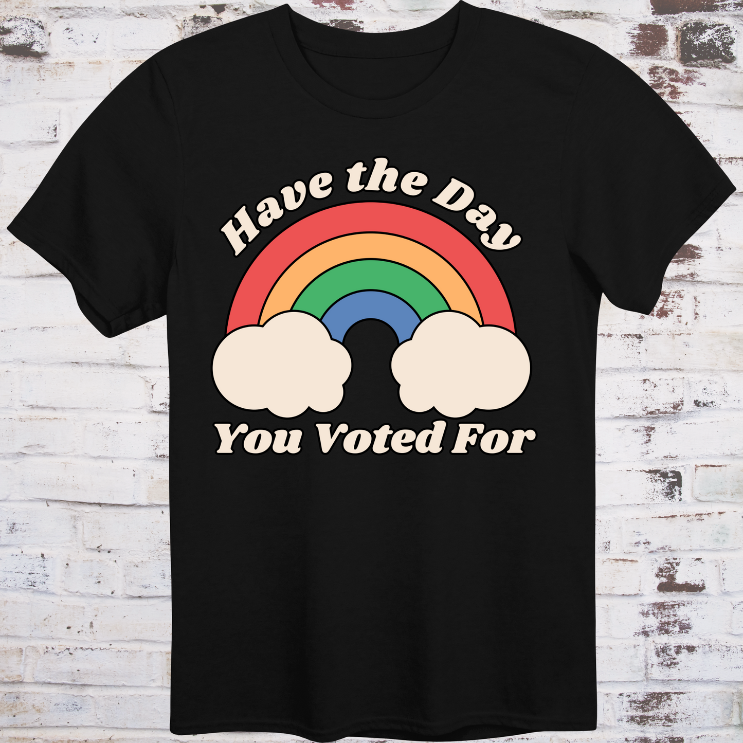Black t-shirt with retro rainbow graphic and white text reading
“Have the Day You Voted For” – passive-aggressive protest shirt by Democratee’s