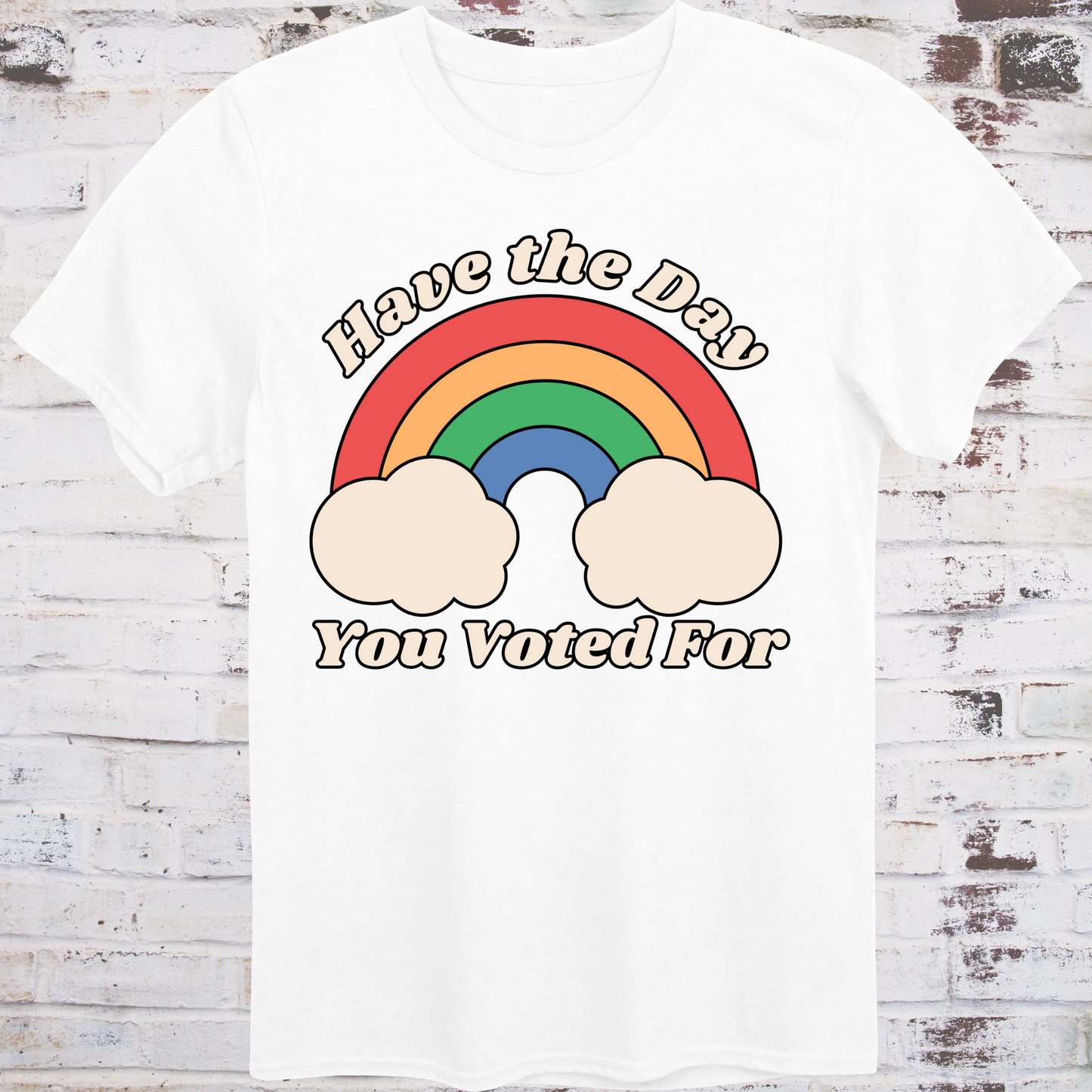 White t-shirt with retro rainbow graphic and white text reading
“Have the Day You Voted For” – passive-aggressive protest shirt by Democratee’s