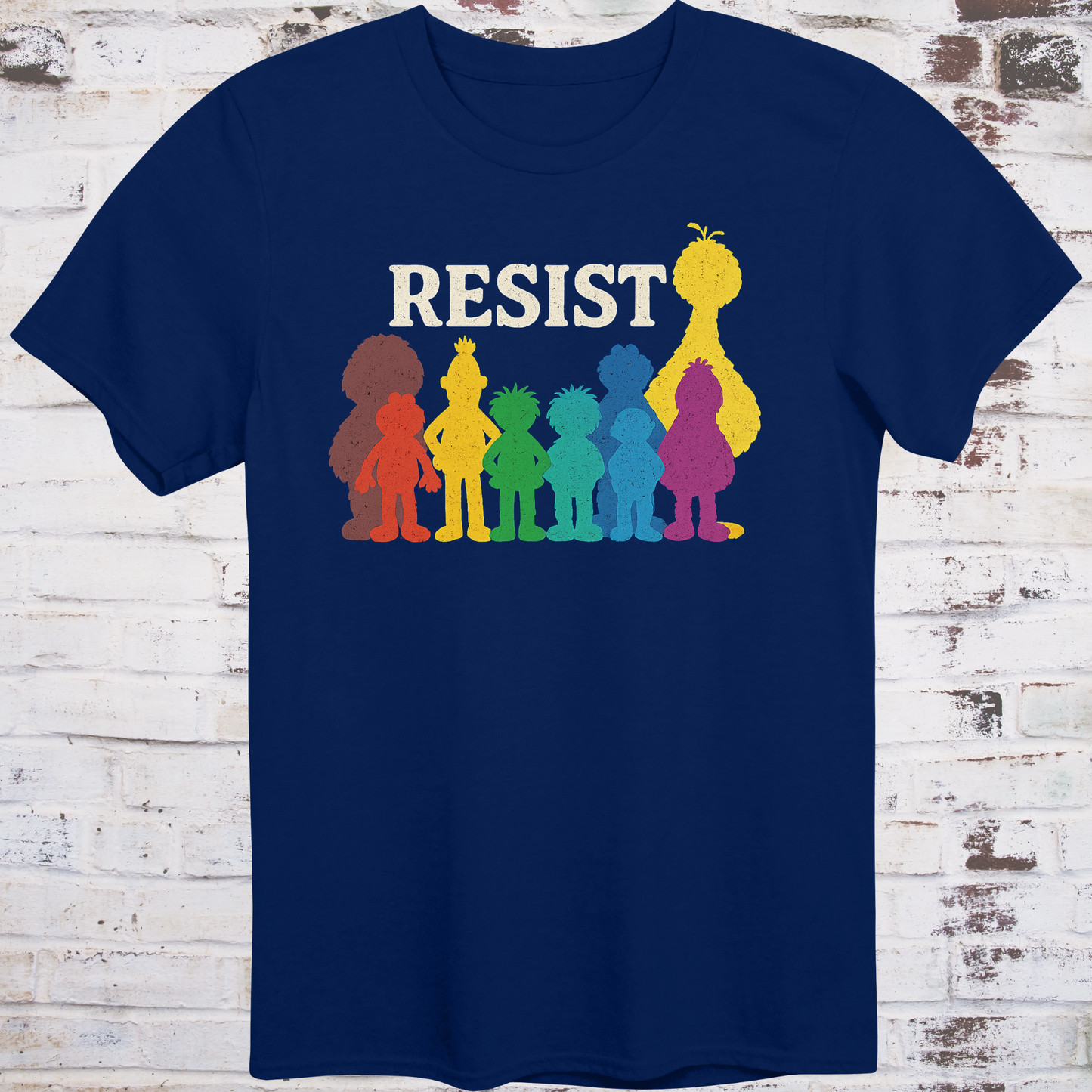 Navy t-shirt with bold white RESIST text above rainbow-colored silhouettes
of classic children’s characters – pride and protest shirt by Democratee’s