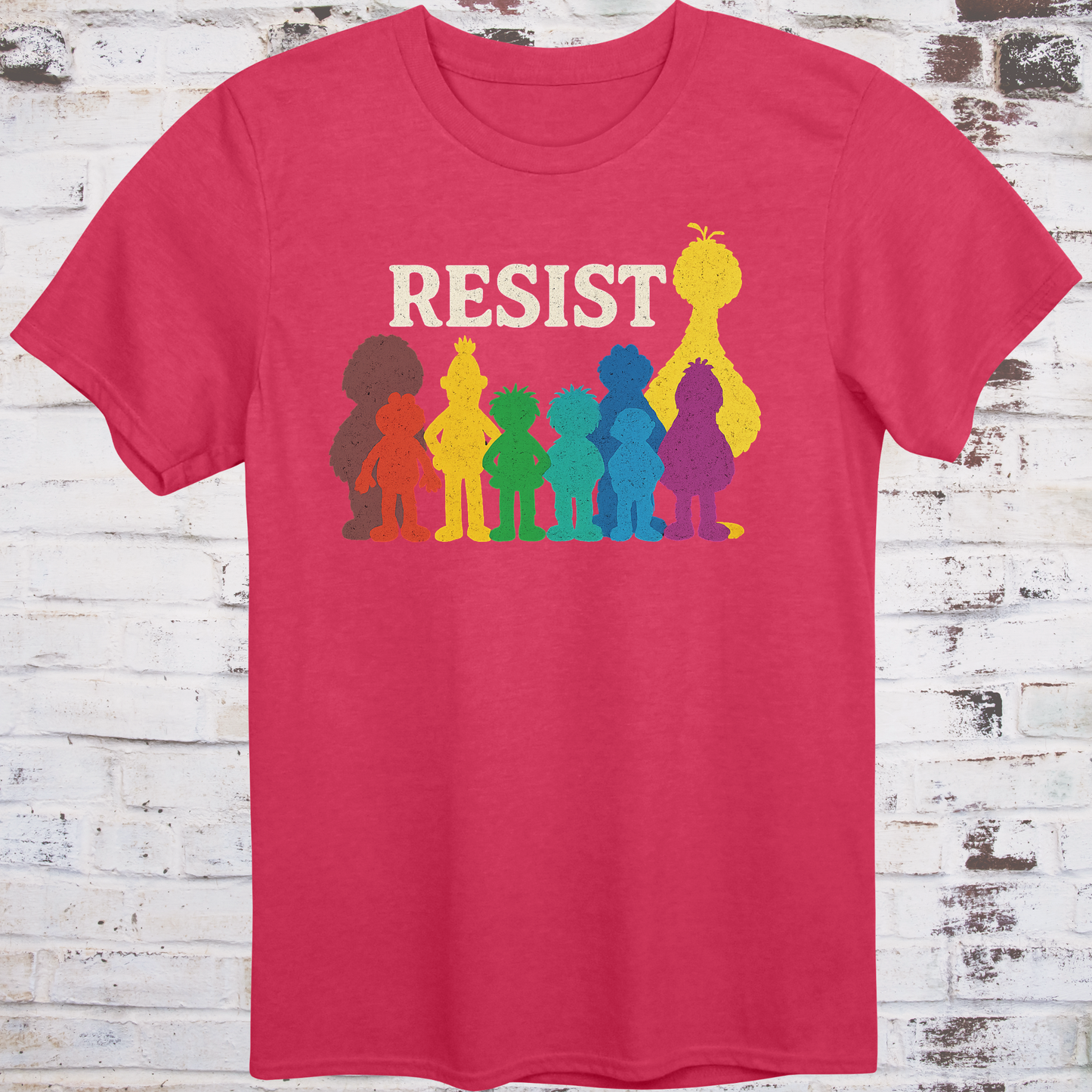 Red t-shirt with bold white RESIST text above rainbow-colored silhouettes
of classic children’s characters – pride and protest shirt by Democratee’s