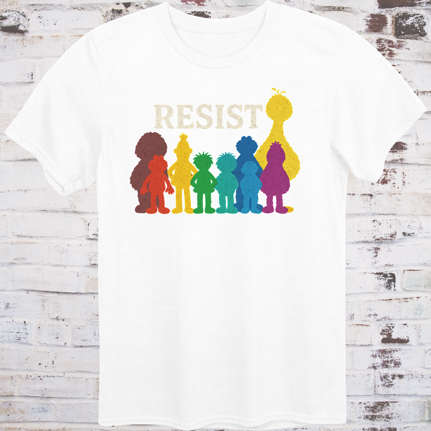 White t-shirt with bold white RESIST text above rainbow-colored silhouettes
of classic children’s characters – pride and protest shirt by Democratee’s