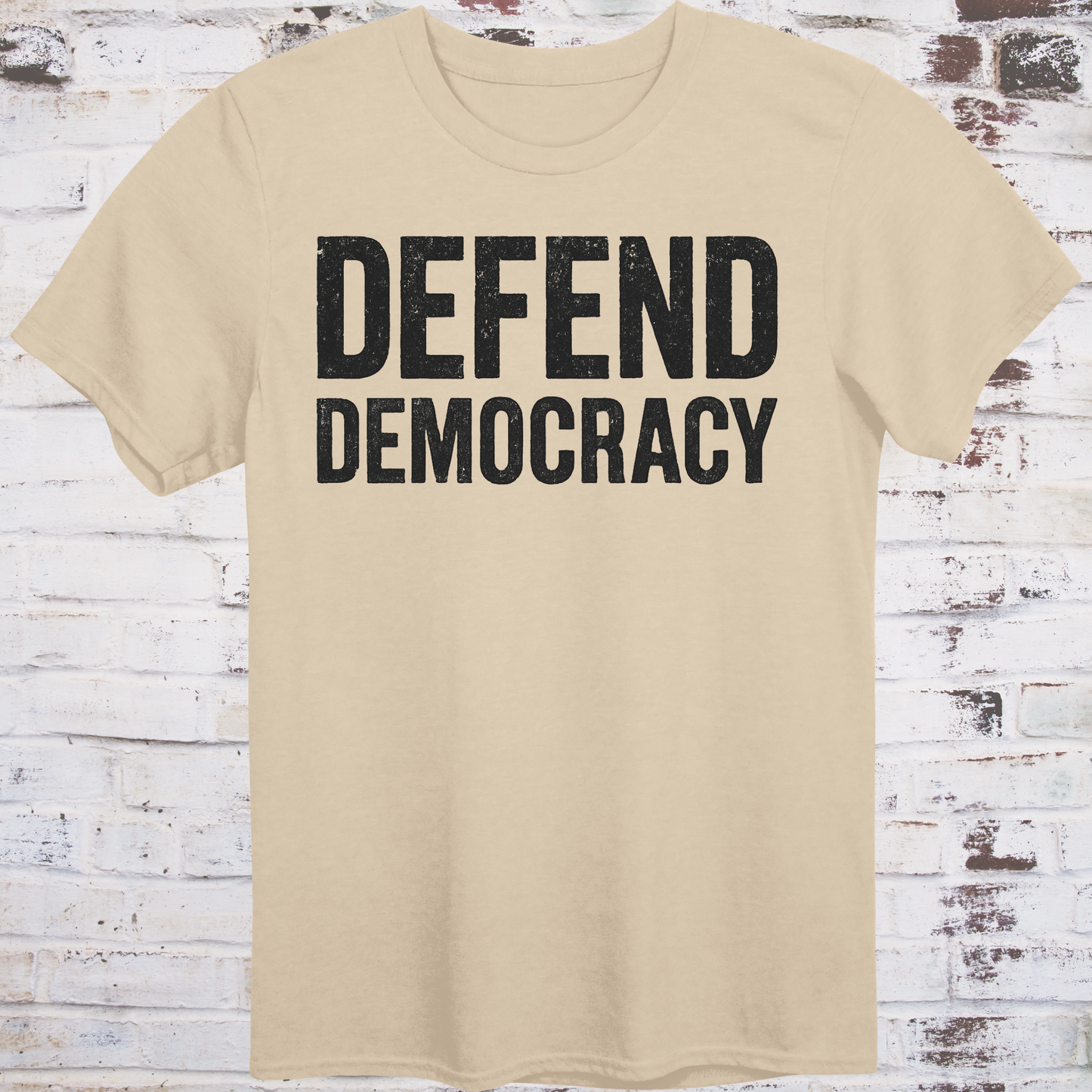 Beige t-shirt with 'DEFEND DEMOCRACY' text on a wooden background