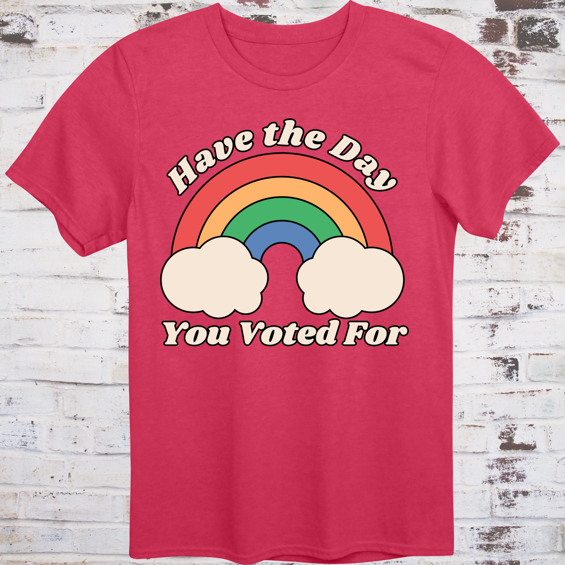Red t-shirt with retro rainbow graphic and white text reading  
“Have the Day You Voted For” – passive-aggressive protest shirt by Democratee’s