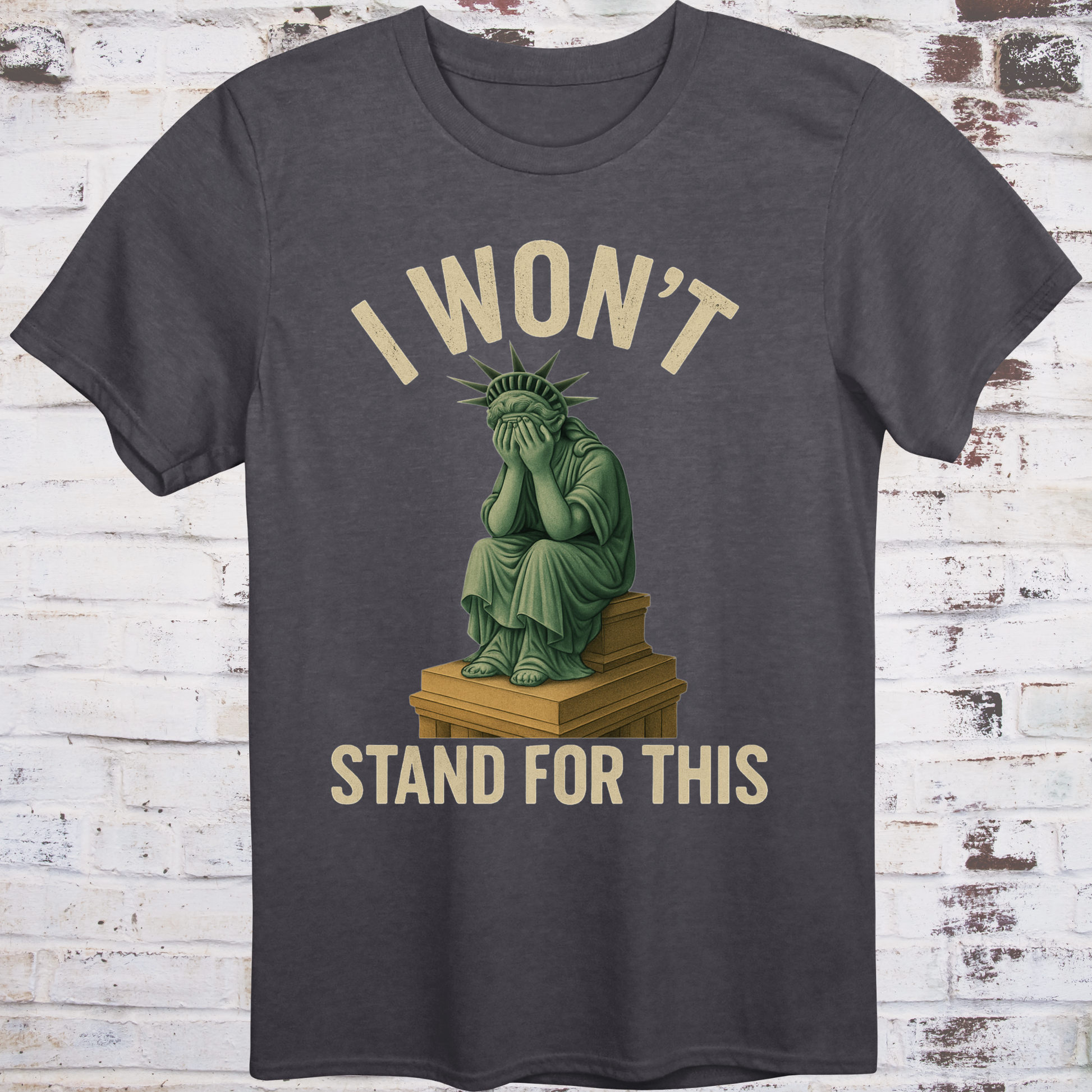 Gray t-shirt with illustration of the Statue of Liberty  
sitting on a pedestal with her face in her hands,  
under text reading "I Won’t Stand for This" –  
progressive protest shirt by Democratee’s