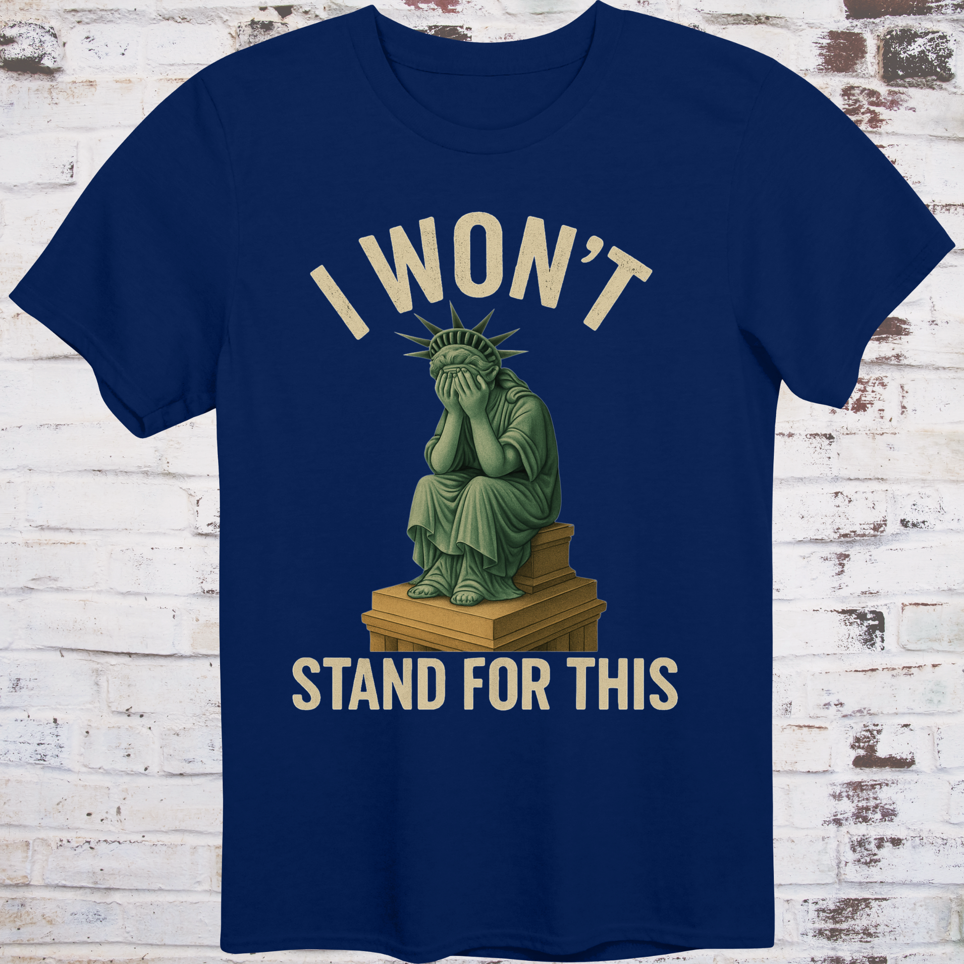 Navy t-shirt with illustration of the Statue of Liberty  
sitting on a pedestal with her face in her hands,  
under text reading "I Won’t Stand for This" –  
progressive protest shirt by Democratee’s