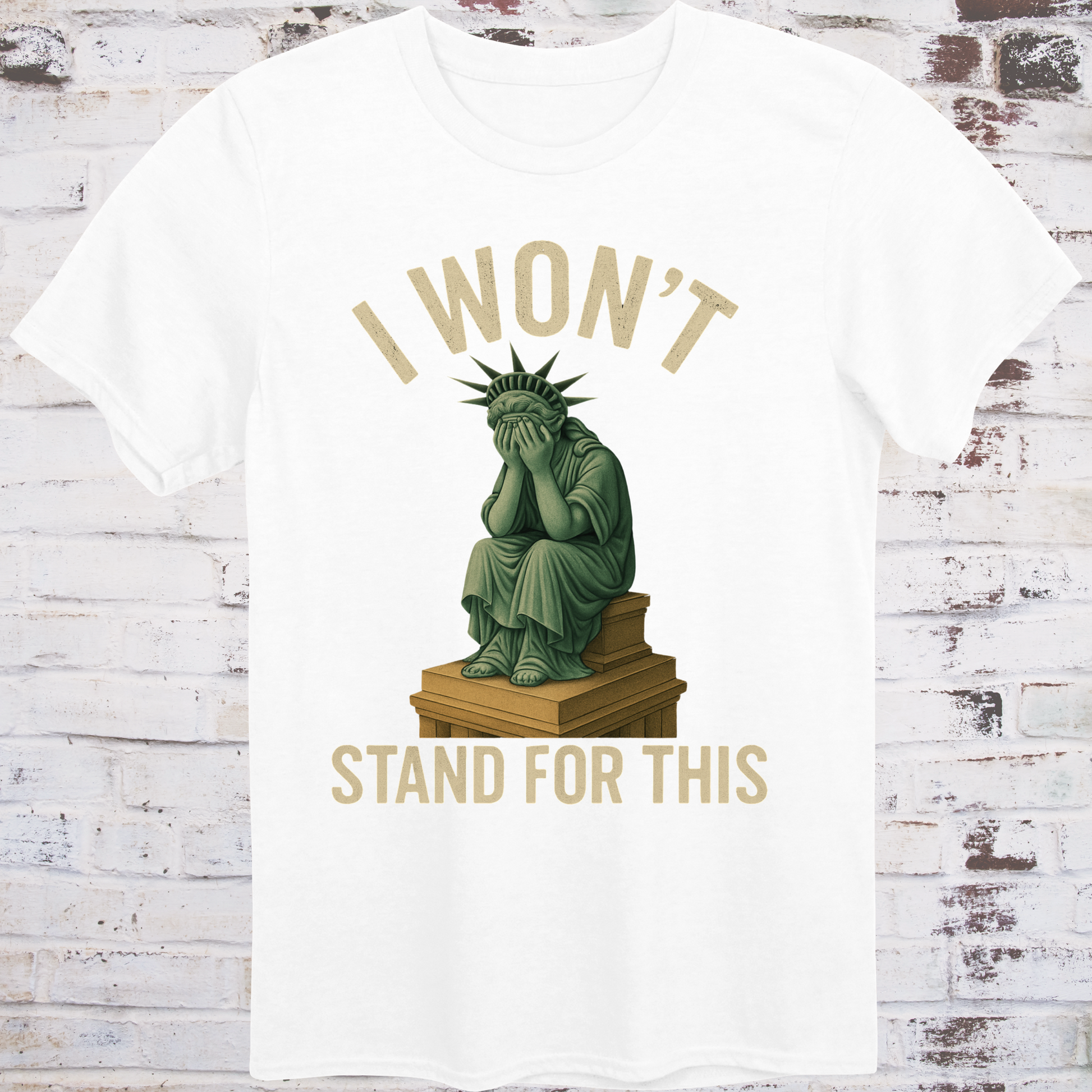 White t-shirt with illustration of the Statue of Liberty  
sitting on a pedestal with her face in her hands,  
under text reading "I Won’t Stand for This" –  
progressive protest shirt by Democratee’s