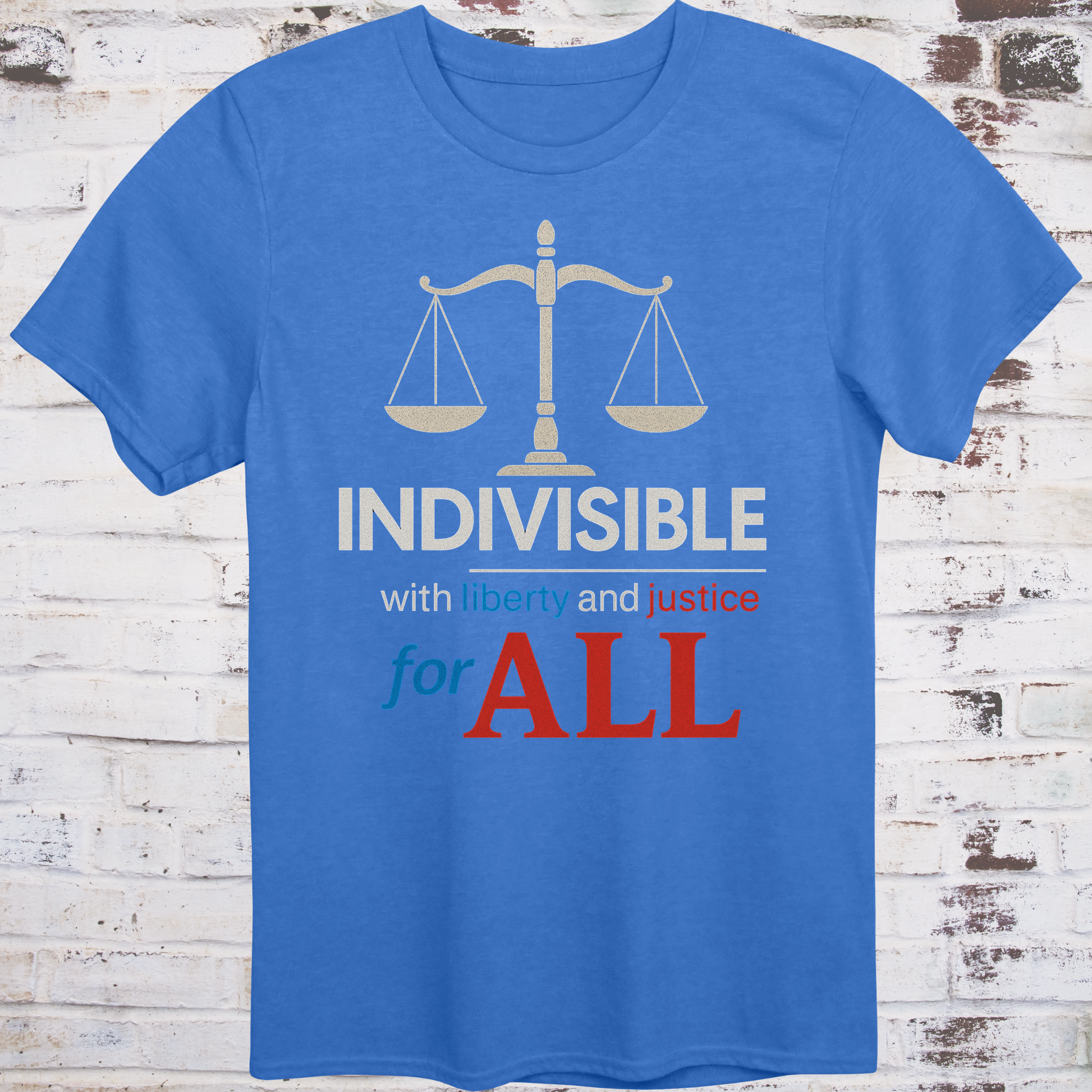 Blue t-shirt with balance scale graphic and bold text reading  
"Indivisible with liberty and justice for all" in red, white, and blue –  
progressive political shirt by Democratee’s