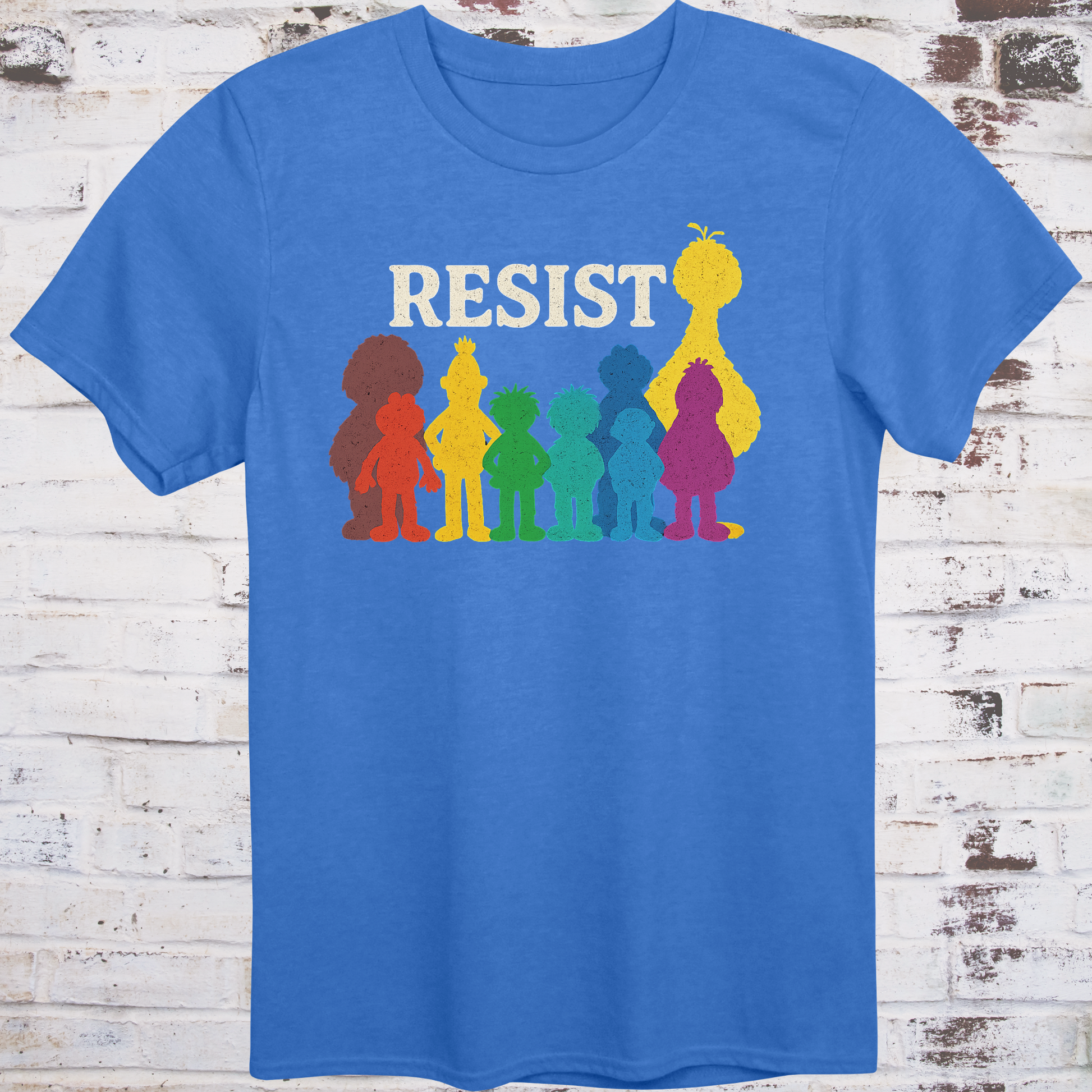 Blue t-shirt with bold white RESIST text above rainbow-colored silhouettes  
of classic children’s characters – pride and protest shirt by Democratee’s