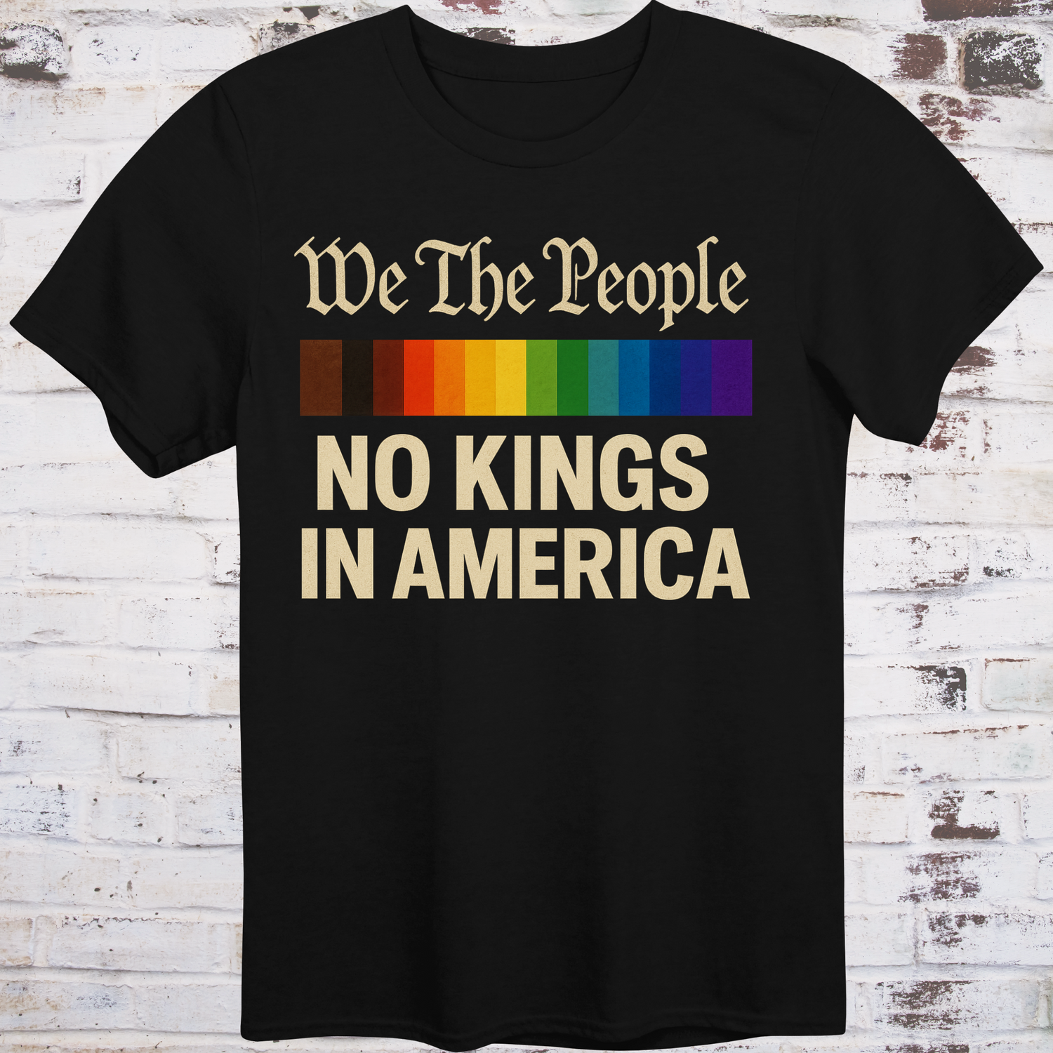 Black t-shirt with the phrase 'We The People' in old script above a Progress Pride flag, and bold text below reading 'No Kings in America' — a pro-democracy, LGBTQ+ inclusive design."
