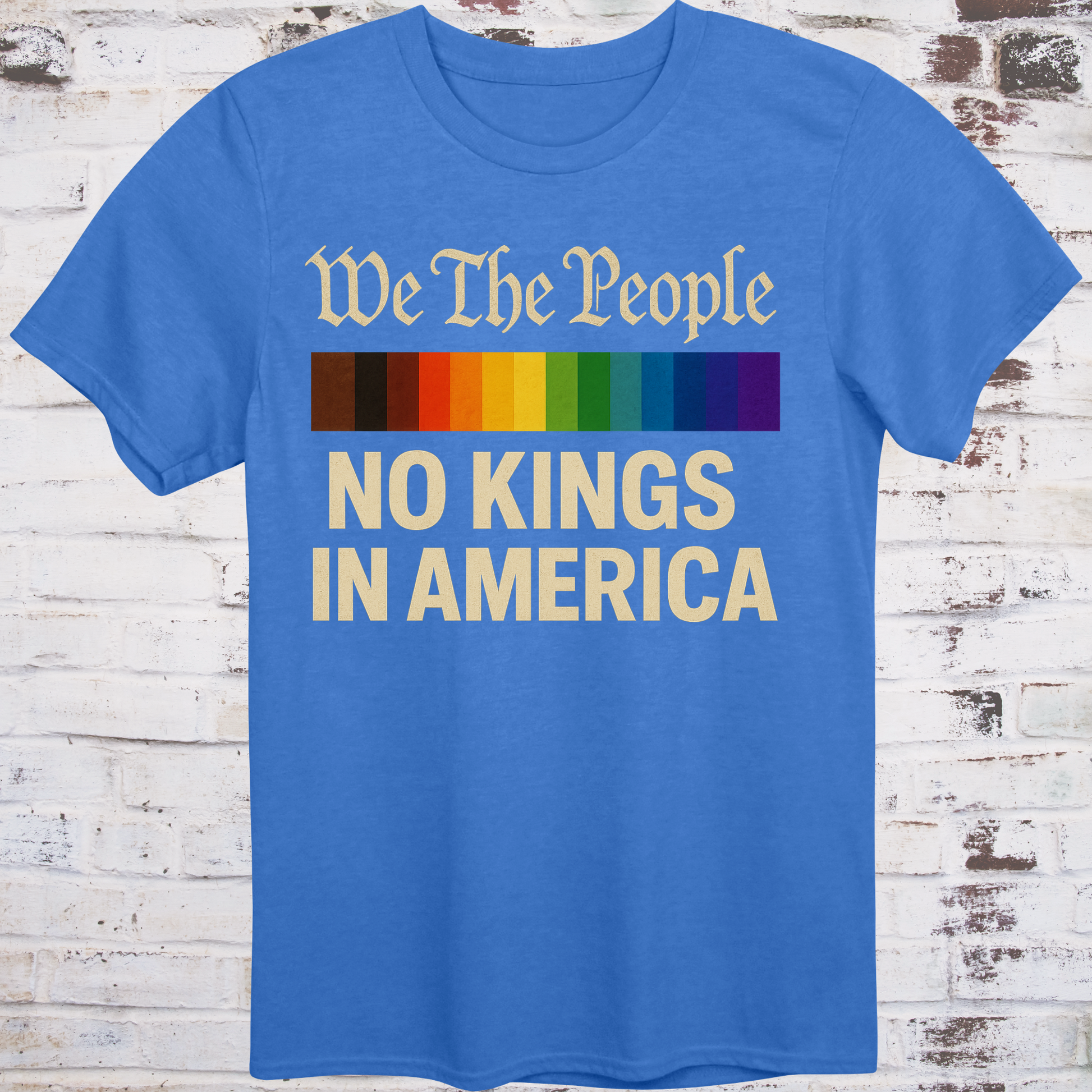 Blue t-shirt with the phrase 'We The People' in old script above a Progress Pride flag, and bold text below reading 'No Kings in America' — a pro-democracy, LGBTQ+ inclusive design."