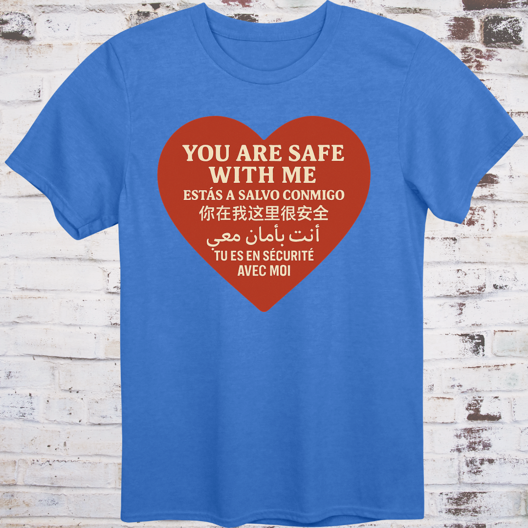 Blue T-shirt with heart graphic reading “You Are Safe With Me” in six languages including English, Spanish, Chinese, Arabic, and French