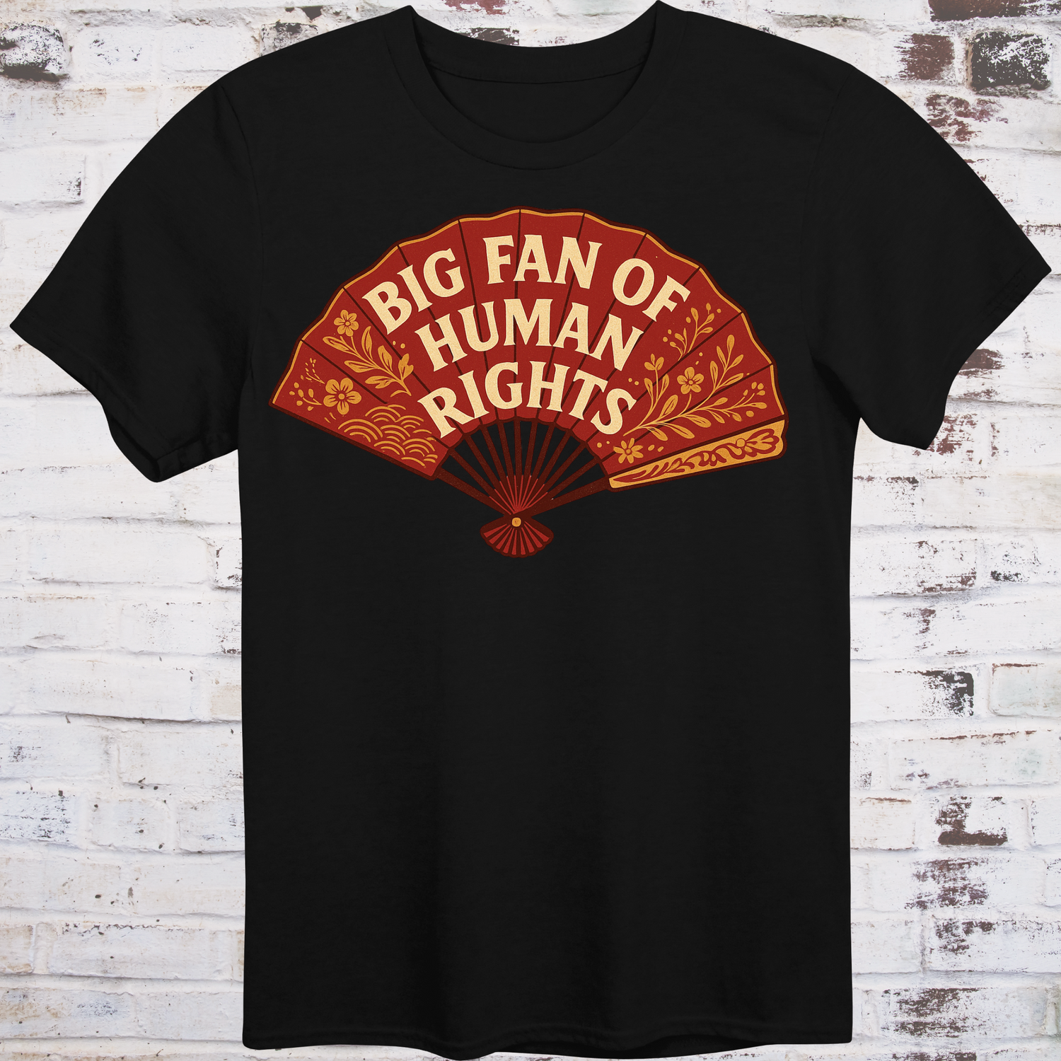 Black t-shirt with a red fan graphic and 'Big Fan of Human Rights' text on a wooden surface.