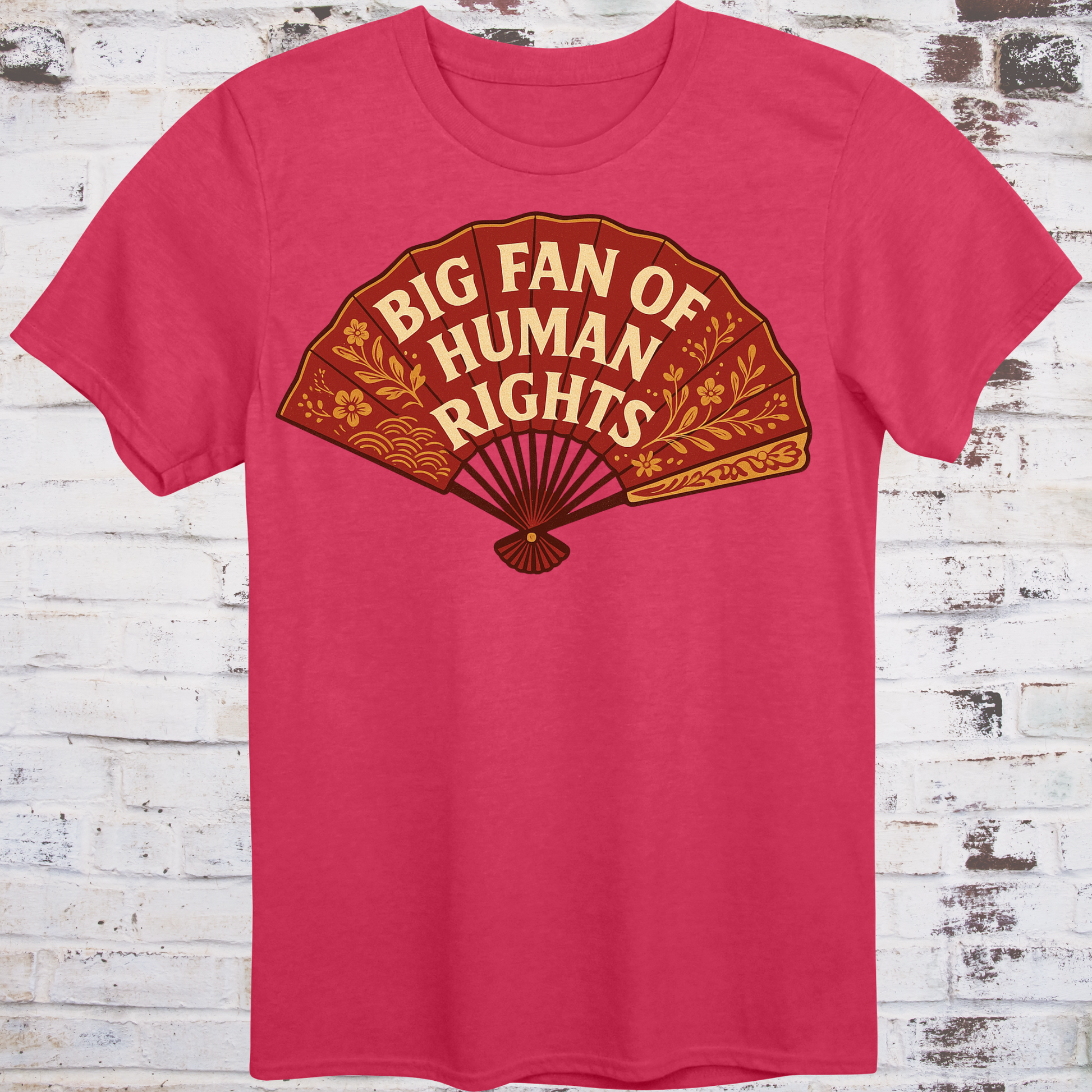 Red t-shirt with a brown graphic of a fan and text 'Big Fan of Human Rights' on a wooden background