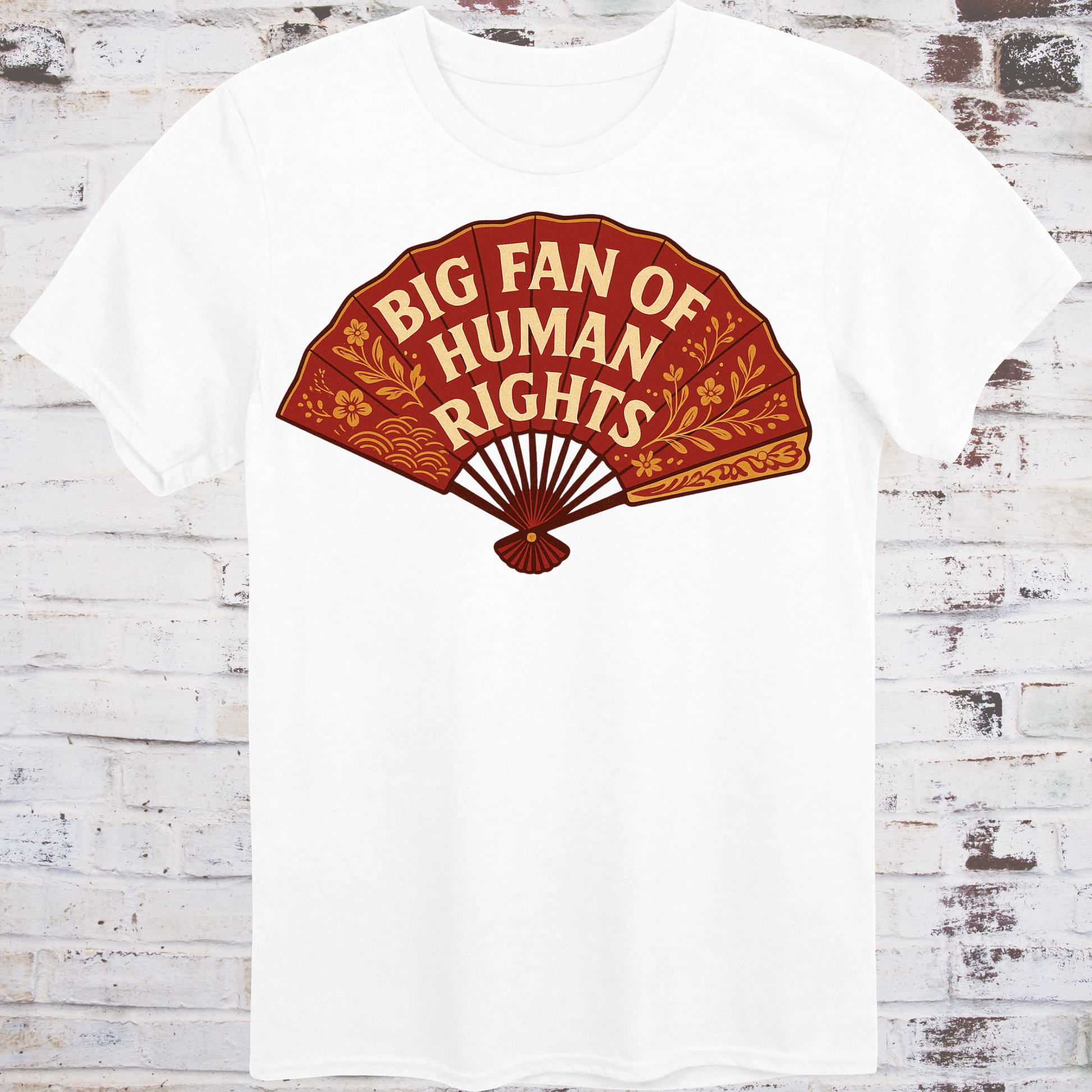 White t-shirt with a red fan graphic and 'Big Fan of Human Rights' text on a wooden background