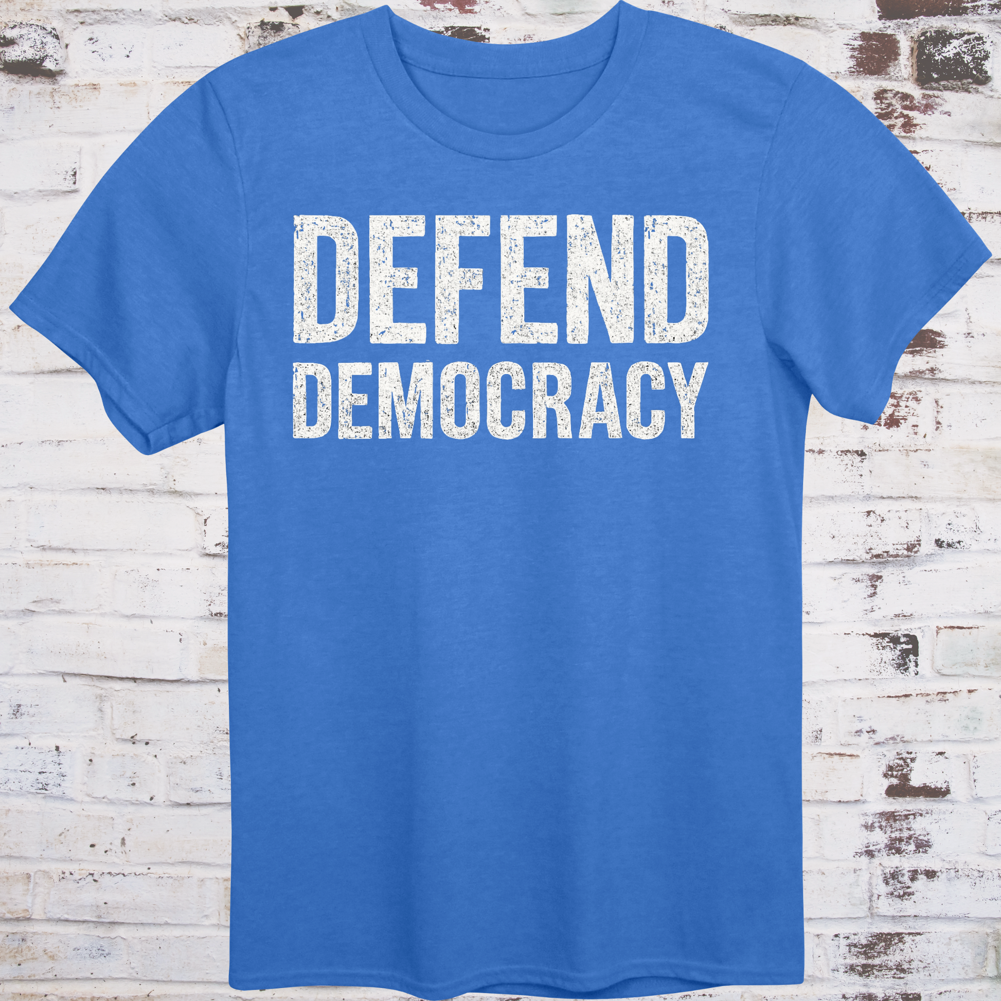 Blue t-shirt with 'DEFEND DEMOCRACY' text on a wooden background