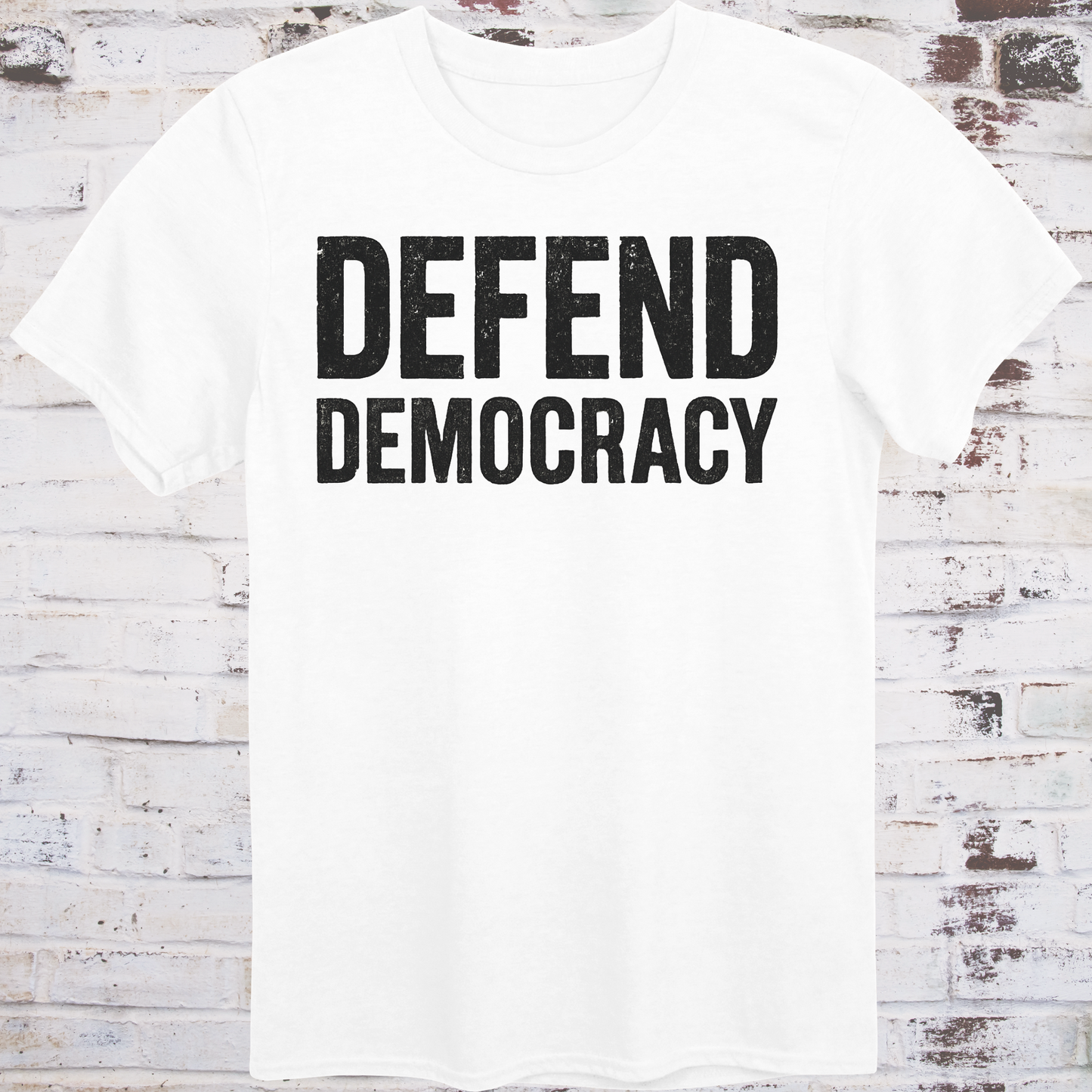 White t-shirt with 'DEFEND DEMOCRACY' text on a wooden background
