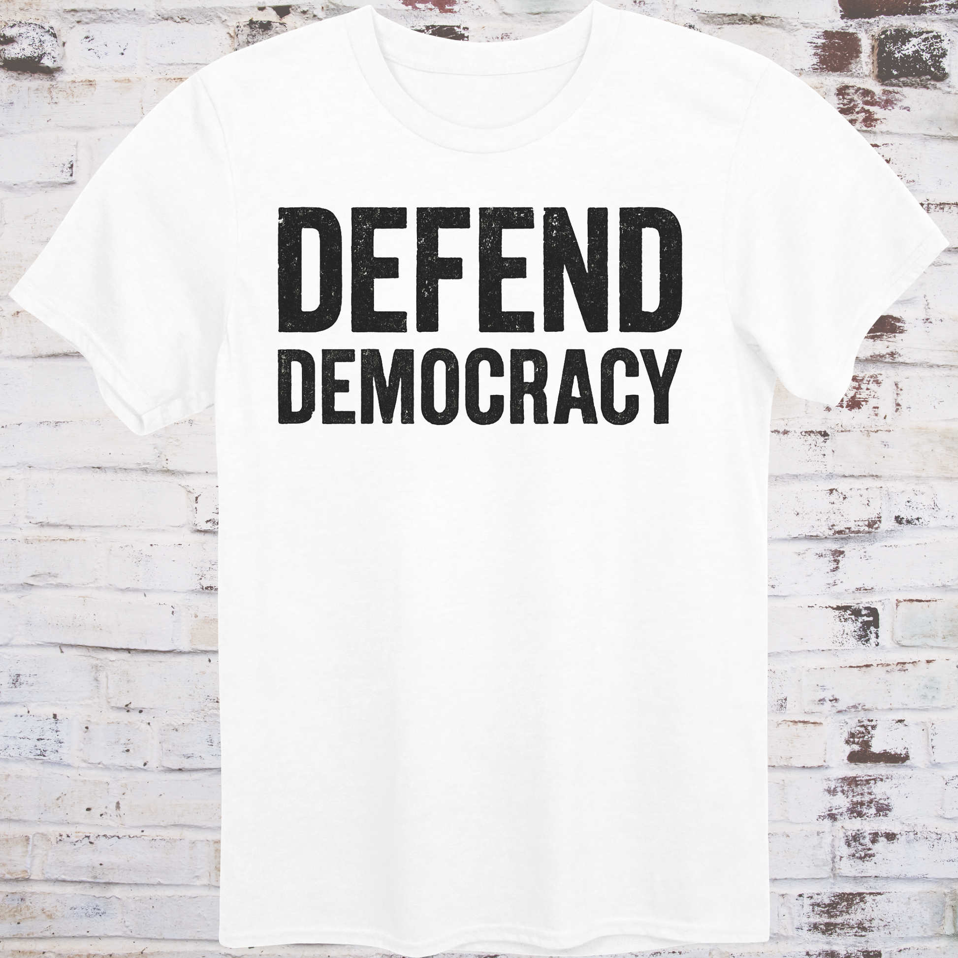 White t-shirt with 'DEFEND DEMOCRACY' text on a wooden background