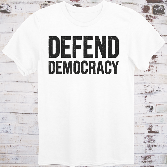 White t-shirt with 'DEFEND DEMOCRACY' text on a wooden background