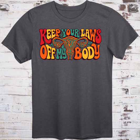 Keep Your Laws Off My Body in massive interlocking 70s bubble letters in deep red, teal, and orange around a stylized uterus, on a warm mustard yellow background.