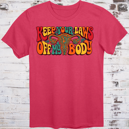 Keep Your Laws Off My Body in massive interlocking 70s bubble letters in deep red, teal, and orange around a stylized uterus, on a warm mustard yellow background.