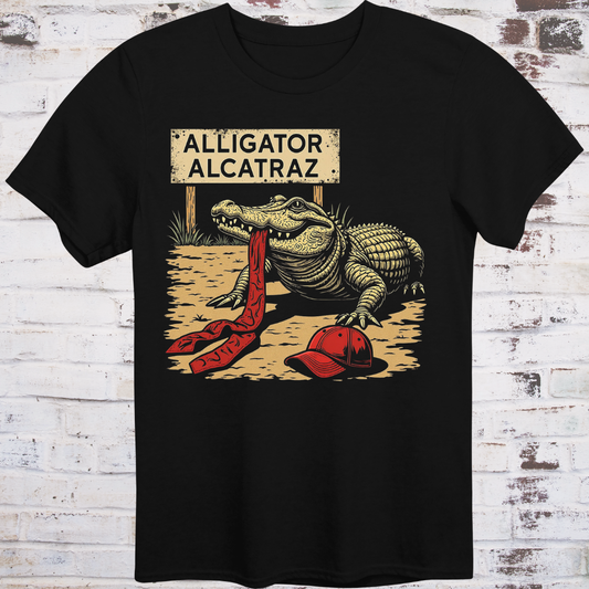 Black t-shirt with an alligator graphic and 'Alligator Alcatraz' sign on a wooden background